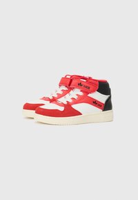 Baskets montantes rouges et blanches avec un accent noir, dotées d'une sangle Velcro, d'un système de laçage et d'une finition en suède texturé.