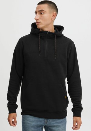 Black fleece hoodie with a half-zip collar, front kangaroo pocket, and red and yellow drawstring accents. Smooth texture, relaxed fit.