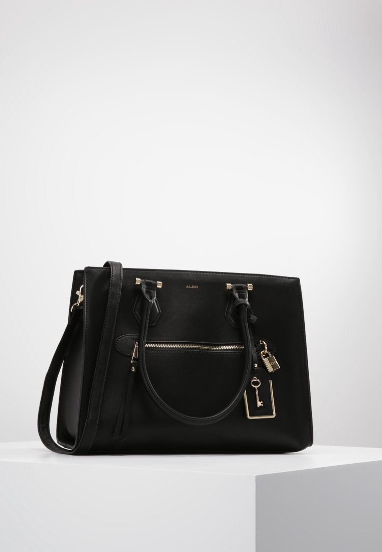 Czarna syntetyczna torebka na podwójnych uchwytach, z zamykaną na zamek przednią kieszenią, złotymi akcentami metalowymi oraz odpinanym breloczkiem w kształcie klucza.