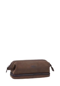 Rudas odinis krepšys tualetiniams reikmenims su lygiu paviršiumi, stačiakampiu pavidalu ir dviguba užtrauktuko uždarymu. Po šonu yra išspaustas logotipas.
