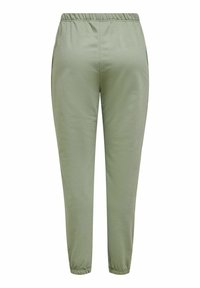 Ljust gröna joggerbyxor i mjukt tyg, med elastisk midja och elastiska fållar vid anklarna.