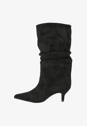 Bota de ante negra de caña media, estilo slouchy, con puntera afilada y tacón bajo tipo kitten.