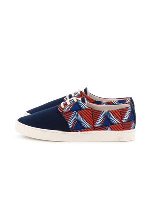 Paire de baskets basses avec bouts bleu marine, semelles blanches et tissu à motifs géométriques rouge, bleu et blanc sur les côtés, avec lacets blancs.