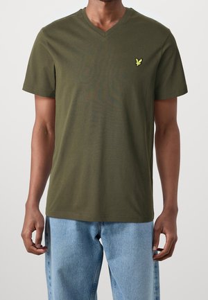 T-shirt in cotone verde oliva con scollo a V e maniche corte, caratterizzata da un piccolo logo giallo sul petto sinistro. Vestibilità classica e texture liscia.