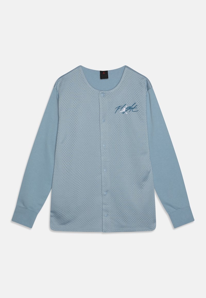 Chemise bleu clair à manches longues avec boutons, panneau avant en maille et texte « Flight » en écriture cursive sur la poitrine gauche.