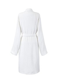 Robe en coton blanc avec un tissu texturé, des manches longues et une ceinture. Présente un col châle et une coupe au niveau du genou.