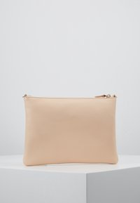 Béžová kožená taštička s hladkým povrchem a zipovým uzávěrem. Má minimalistický design, obdélníkový tvar a decentní švy.