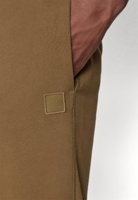 Bruine katoen joggers met een slim fit, met een vierkant label met het reliëf "BOSS" en een zijsne ontwerp. Gladde textuur en strakke randen.