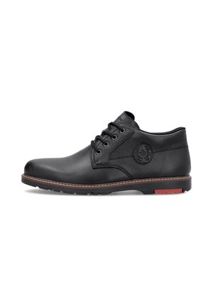 Schwarzer Leder-Schnürschuh am Knöchel mit braunen Nähten an der Sohle und rundem Logo-Patch an der Seite, im Profil vor weißem Hintergrund dargestellt.