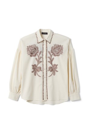 Blusa cremosa de manga larga con bordado floral marrón en la parte delantera, adorno decorativo a lo largo de la línea de botones y el cuello, y un cuello puntiagudo.