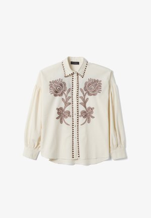 Blusa cremosa de manga larga con bordado floral marrón en la parte delantera, adorno decorativo a lo largo de la línea de botones y el cuello, y un cuello puntiagudo.
