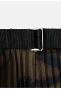 Tela negra plisada con un patrón de tie dye. Presenta una cinturilla ancha texturizada en negro y un acento de hebilla plateada.