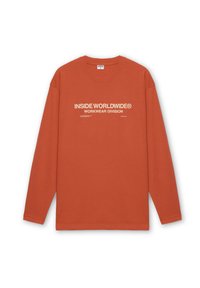 Camiseta de algodón de manga larga, color naranja, con un logo impreso en blanco que dice "INSIDE WORLDWIDE® WORKWEAR DIVISION" en la parte frontal.