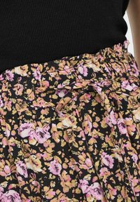 Gonna floreale con sfondo nero e motivo rosa e giallo, con cintura regolabile, design plissettato, realizzata in tessuto leggero.