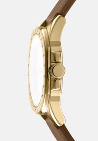 Gouden horloge met een grote ovale kast met een gladde oppervlakte, versierd met kleine kristallen rond de bezel, en een bruin lederen band.