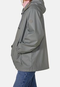 Lightweight grey rain jacket with a hood, elastic cuffs, front pockets, and a logo patch on the sleeve. Textured water-resistant material.