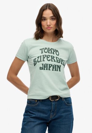 T-shirt en coton vert menthe clair à manches courtes, portant un texte rétro noir "TOKYO SUPERDRI JAPAN" sur le devant.