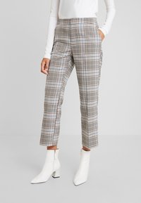 Rutiga byxor med en blandning av bruna, blå och svarta mönster. Materialet har en mjuk textur och har sidofickor samt en skräddarsydd design.