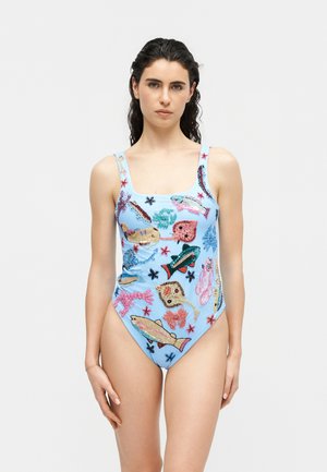 Mujer de cabello oscuro con un traje de baño de una pieza color azul claro decorado con coloridas criaturas marinas bordadas y estrellas de mar.