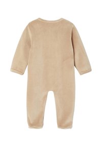 Beige Langarm-Babykombination mit Fuß, aus weichem Plüschstoff, von hinten vor einem weißen Hintergrund gezeigt.