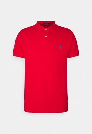 Rød polo T-shirt med korte ærmer, krave og to knapper, med en lille blå broderet logo på venstre bryst.