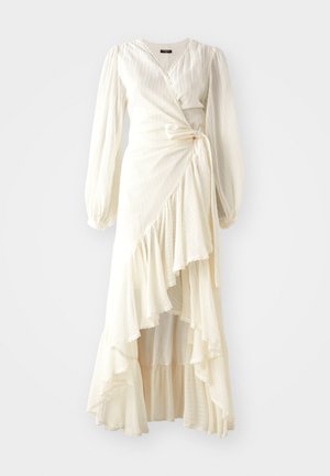 Šviesiai kreminės spalvos suknelė su ilgomis rankovėmis ir raukšlėtu apvadu. Pagaminta iš lengvos, tekstūruotos medžiagos, su juosmeniu susiūtu raiščiu ir V formos iškirpte.