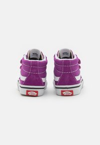 Lila Wildleder High-Top Sneaker mit weißen Lederseitenstreifen, schwarzem Gummisohle und rotem Vans-Logo auf der Ferse. Fünf Paar Ösen.