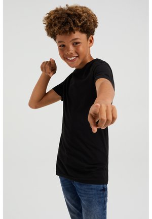 Svart bomull T-shirt med rund halsringning, korta ärmar och avslappnad passform, ihop med ljusblå denimjeans.