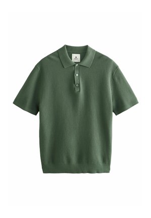 Polo vert à manches courtes en tissu texturé avec col côtelé et patte à trois boutons. Ourlet droit en bas.