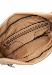 Interno della borsa color marrone chiaro con fodera in tessuto liscia, una tasca con zip e una tasca a soffietto. Presenta una cerniera scura e accenti di cucitura.