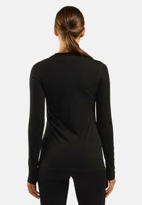 Long-sleeve black top made from soft fabric, featuring a fitted design and minimal seams for a sleek look. No visible patterns or hardware.