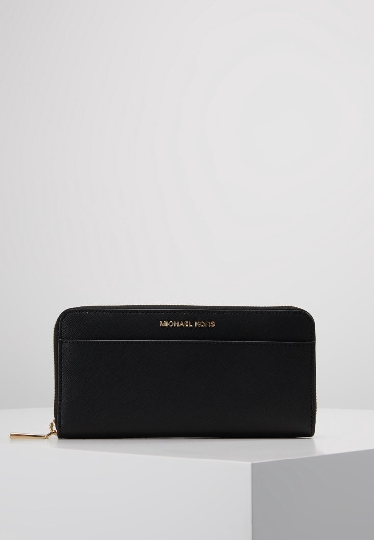 Portefeuille en cuir noir avec fermeture éclair tout autour, tirette dorée et logo « Michael Kors » embossé en doré sur le panneau avant.