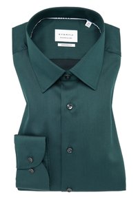Camicia a maniche lunghe di un verde scuro, piegata ordinatamente. Parte anteriore con bottoni neri, colletto classico e etichetta nel colletto. Design in taglio moderno.