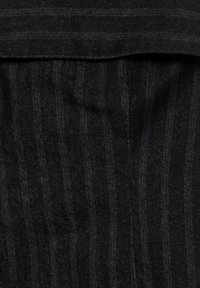Material cu dungi negre, cu o textură fină; pliul orizontal în partea de sus; model de țesătură diagonală vizibil pe întreaga suprafață.