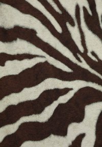 Brown and ivory faux fur with a zebra stripe pattern, featuring smooth texture and varying stripe widths on a soft surface.
