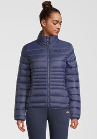 Námornícky modrá puffa bunda s vysokým golierom, horizontálnym prešívaním, predným zipom a decentným logom na hrudi. Hladký, lesklý materiál.