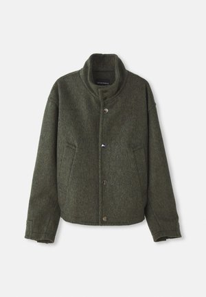 Blouson en laine verte avec col montant, deux poches latérales et fermetures à boutons métalliques. Présente une coupe décontractée et une texture douce.