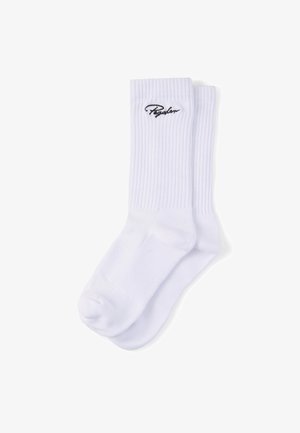 Weiße Sportsocken mit geripptem Muster und schwarzem, gesticktem "Regular"-Logo nahe dem oberen Bündchen, flach auf weißem Hintergrund dargestellt.