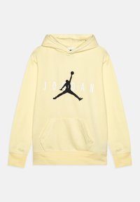 Sudadera amarilla de tela suave, con una gran silueta negra de un jugador de baloncesto y "JORDAN" en letras blancas. Incluye bolsillo frontal.