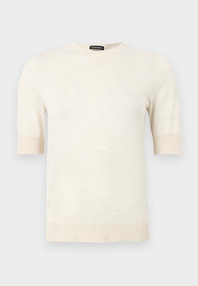 Pull à manches courtes de couleur crème avec col rond, poignets et ourlet côtelés, étiquette « SUPREME MERINO » au col.