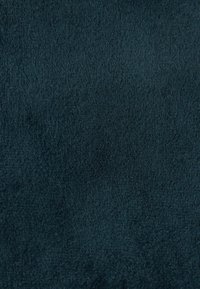 Tessuto verde petrolio scuro con superficie morbida e strutturata, caratterizzato da una finitura vellutata e colore uniforme. Adatto per tappezzeria o uso decorativo.