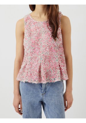 Mouwloze roze textuurige peplumtopp met meerkleurige bloemendetails, gedragen met lichtblauwe spijkerbroek door een staand persoon.