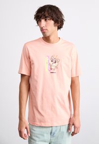 Gaiši rozā kokvilnas T-krekls ar centrā esošu multfilmu varoņa attēlu, ar īsām piedurknēm un apaļu izgriezumu.