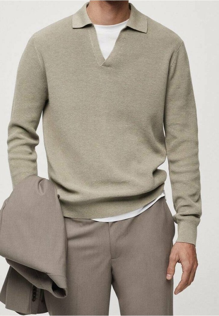 Lichtgroene gebreide trui met een V-hals en kraag, gecombineerd met grijze broek. De stof lijkt een textuur te hebben en zacht te zijn.