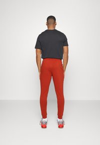 Nike Performance TAPER - Træningsbukser - rugged orange black