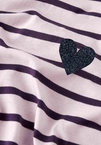 Tissu rayé rose clair avec des lignes violet foncé, orné d'une appliqué en forme de cœur noir pailleté. Surface douce et texturée.