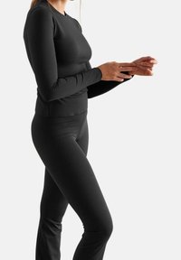 Zwarte langjarige top en aangesloten broek van rekbaar materiaal. Gladde textuur met een slim fit silhouet, geschikt voor sportkleding.