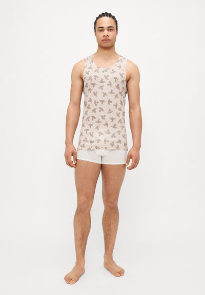 Beige Tanktop mit braunem Schmetterlingsmuster, aus Baumwolle, breite Träger, kombiniert mit weißen Boxershorts. Einfaches Design und bequeme Passform.