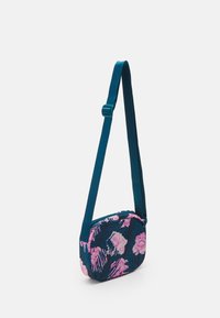 Borsa a tracolla floreale con base in tessuto blu e motivi a fiori rosa, forma arrotondata e tracolla regolabile color teal.