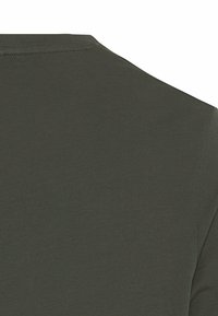 Mørkeoliven grøn T-shirt stof med en glat, let strækbar tekstur; har en simpel rund halsudskæring og korte ærmer.